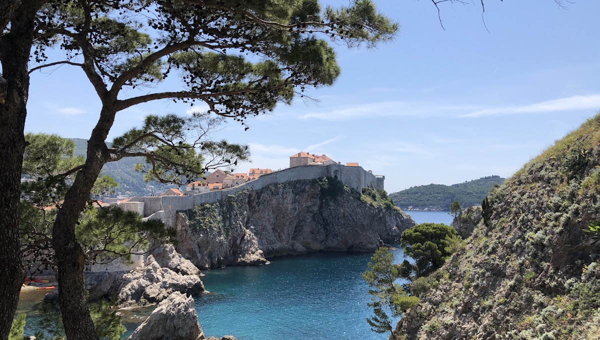 Dubrovnik's Old Town walls viewed from Fort Lovrijenac at golden hour with orange rooftops and the Adriatic Sea
