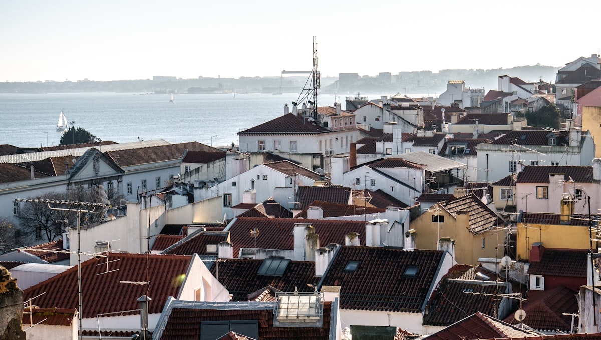 Morning light over the Alfama district rooftops with the Tagus river visible in the background