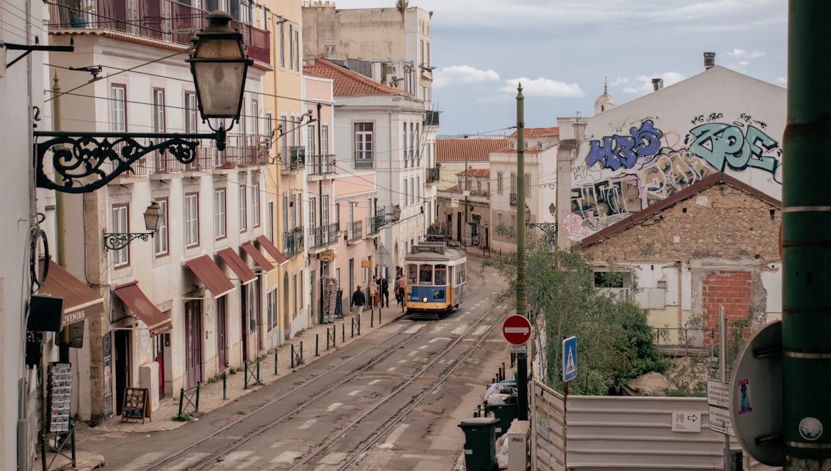 Tram 28 navigating the steep narrow streets of the Alfama neighborhood at dusk