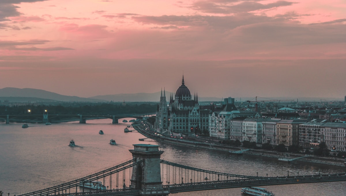Hungarian Parliament Building illuminated at night reflecting in the Danube River