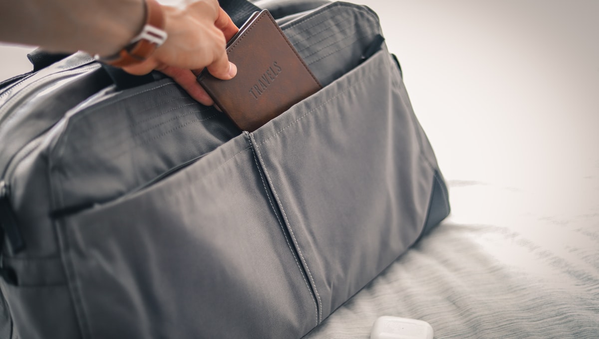Luggage on a conveyor belt at an airport baggage claim with various airline bag tags visible