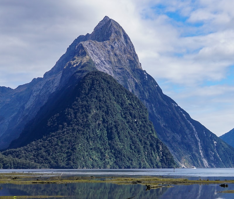 Milford Sound bei Morgengrauen mit dem markanten Mitre Peak, der sich im stillen Wasser spiegelt