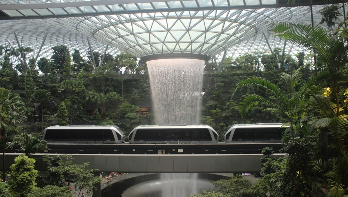 Singapore Changi Airport's Jewel indoor waterfall with lush greenery surrounding the central cascade
