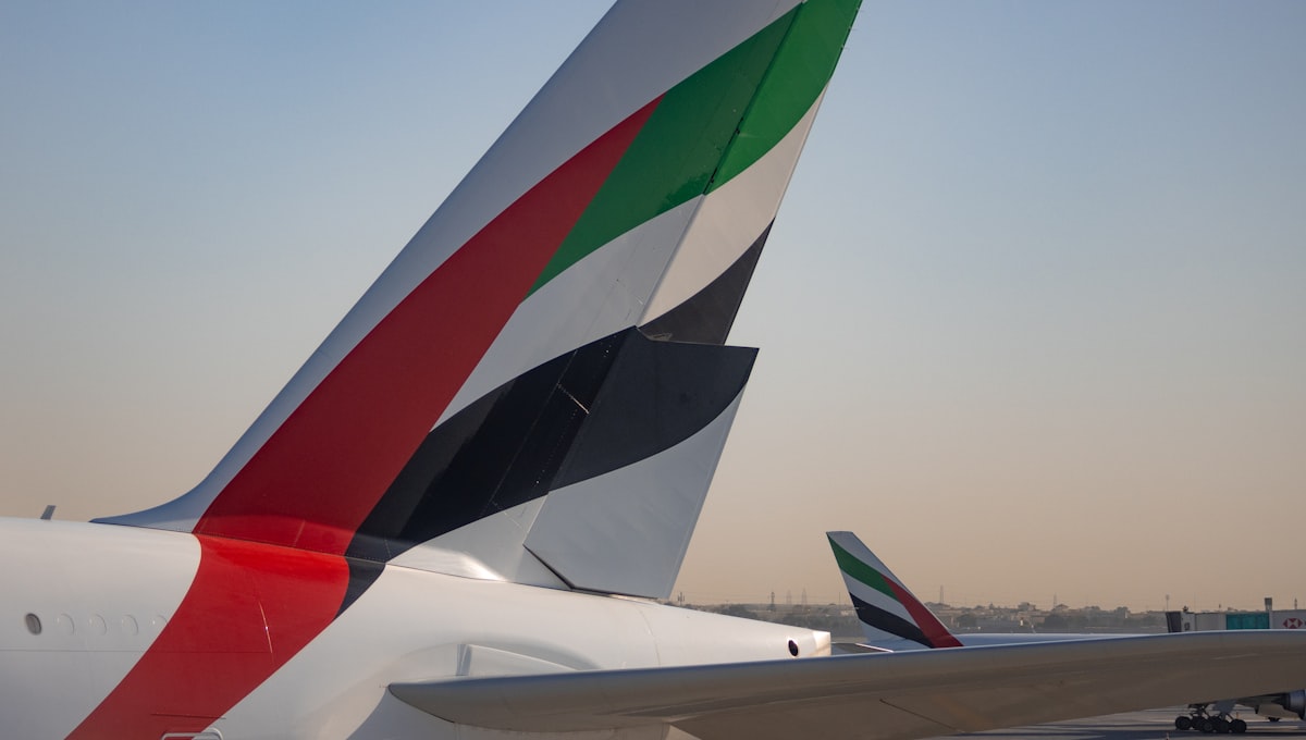 Emirates A380 aircraft landing at Dubai International Airport at sunset