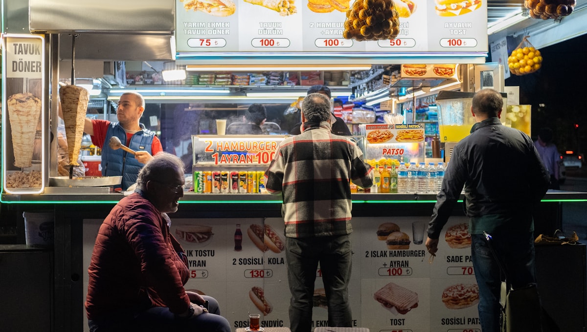 a group of people standing in front of a food stand