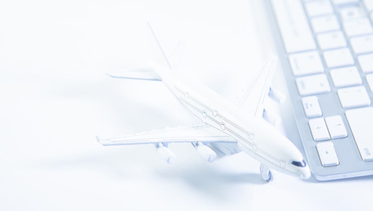 Laptop showing a flight booking comparison tool with prices across multiple regional markets